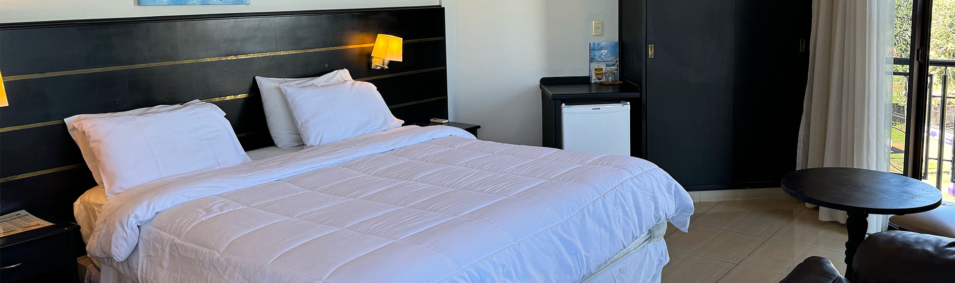 Habitación Ejecutiva de De La Costa Hotel, con cama doble y acceso al balcón