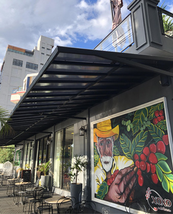 Mesas al aire libre y mural de XOXO Café & Restó