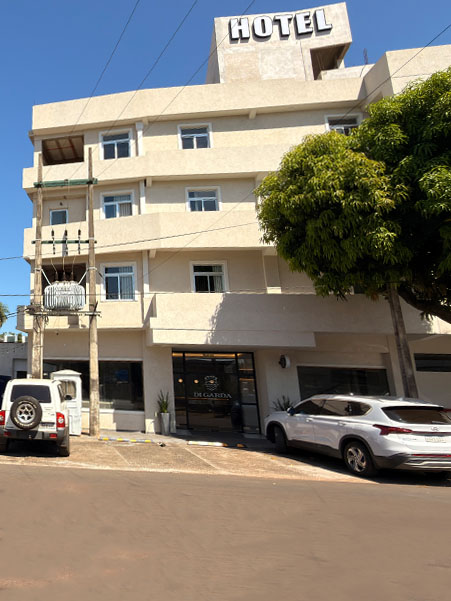 Di Garda Hotel en Encarnación: fachada clara, entrada y árbol frente al edificio