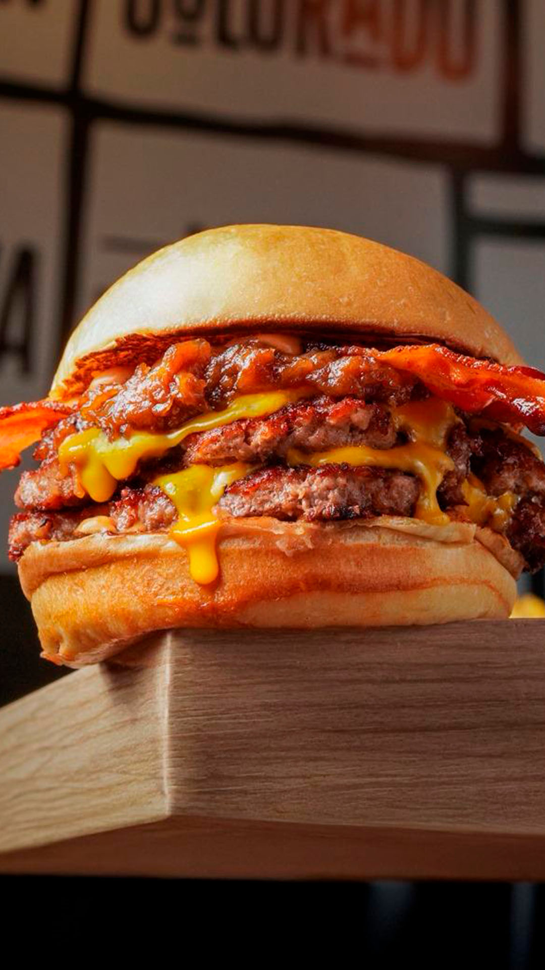 Hamburguesa de Landderburger con dos medallones, cheddar y panceta, sobre una tabla de madera