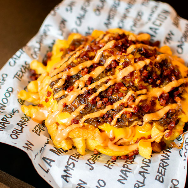 Papas Animal Style de Landderburger, cubiertas con cheddar, cebolla caramelizada y salsa